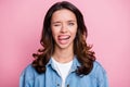 Photo of cute attractive flirty young woman bite tongue wink eye isolated on pastel pink color background