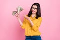 Photo of cute brunette hairdo young lady show money wear yellow shirt eyewear isolated on pink color background