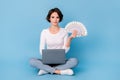 Photo of cute busy lady dressed white shirt legs crossed working modern device cash fan isolated blue color background