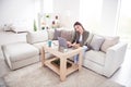 Photo of cute busy young woman dressed green shirt sitting couch talking workig modern gadgets indoors house home room