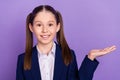 Photo of cute charming school girl wear blue uniform holding arm empty space smiling isolated purple color background