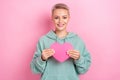 Photo of cute cheerful smile blonde short hair girl hold paper love symbol postcard valentine gift from boyfriend