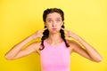 Photo of cute childish young woman pigtails wear tank top pointing fingers bloated cheeks isolated yellow color