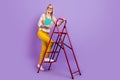 Photo of cute clever mature lady dressed print blouse glasses holding copybooks rising stairs smiling purple