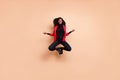 Photo of cute concentrated curly dark skin woman dressed red blazer jumping open chakras isolated beige color background