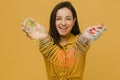 Photo of cute female with nice smile plays slinky. Wears yellow shirt, isolated yellow color background