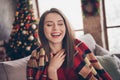 Photo of cute funny girl sit sofa hand chest eyes close wear blanket red pullover in decorated x-mas living room indoors