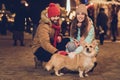 Photo of cute funny wife husband embracing walking small dog corgi friend puppy outside city fair street