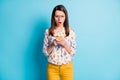 Photo of cute girl hold telephone scare face open mouth wear glasses geometry print shirt yellow pants isolated blue Royalty Free Stock Photo