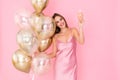 Photo of cute girl raises up glass of champagne holds many air balloons. came to party. Celebration Royalty Free Stock Photo