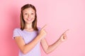 Photo of cute happy cheerful little girl point index fingers empty space advert isolated on pink color background Royalty Free Stock Photo