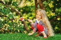 Photo of cute little girl sitting on green grass