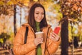 Photo of cute lovely lady smiling hand hold telephone look screen cup drink coffee post share recent photo autumn park