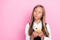 Photo of cute minded girl hold device interested look empty space question uncertain unsure dilemma isolated on pink Royalty Free Stock Photo