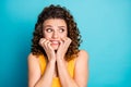 Photo of cute neurotic redhead girl biting nails look side empty space horrified wear yellow tank-top isolated blue