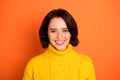 Photo of cute nice good friendly charming girl smiling with her white teeth while isolated with orange background