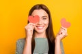 Photo of cute playful girl looking out of one hearts given her as present for valentine day while isolated with yellow Royalty Free Stock Photo