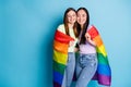 Photo of cute pretty lesbians couple ladies parade tolerance same sex marriages hugging gay rainbow flag leaning close