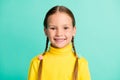 Photo of cute pretty little blond girl wear yellow sweater happy good mood smile isolated on teal color background Royalty Free Stock Photo