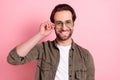 Photo of cute pretty young man wear brown shirt arm eyewear smiling isolated pink color background Royalty Free Stock Photo