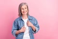 Photo of cute shiny age woman dressed jeans outfit smiling arms shirt looking empty space isolated pink color background Royalty Free Stock Photo