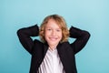 Photo of cute small blond boy hands head wear uniform  on blue color background Royalty Free Stock Photo