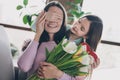 Photo of cute sweet kid girl prepare surprise for loving mom close hand her eyes hold blossom tulip bunch box in Royalty Free Stock Photo