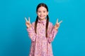 Photo of cute young girl show double v sign everyone unknown person wear dress first day kindergarten isolated on blue Royalty Free Stock Photo