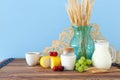 Photo of dairy products over old wooden table and pastel background. Symbols of jewish holiday - Shavuot