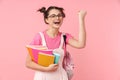 Photo of delighted girl holding exercise books and making winner gesture Royalty Free Stock Photo