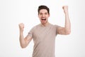 Photo of delighted happy man 30s in casual t-shirt screaming and