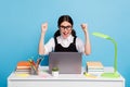 Photo delighted high school girl sit table study remote use laptop celebrate good grades test raise fists scream wear Royalty Free Stock Photo