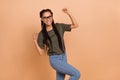 Photo of delighted overjoyed girl raise fists celebrate triumph luck isolated on beige color background