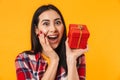 Photo of delighted young woman expressing surprise and holding gift box