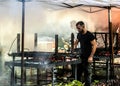 Photo depicting people making a grilled meat immersed in smoke. fire and coals.