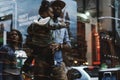 Afro-American man carrying his child on his arms while strolling in Times Square, New York.