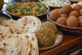 This photo depicts a close-up view of various plates of food arranged on a table, Variety of traditional Lebanese flatbreads