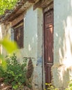 This photo depicts the facade of an abandoned house in the midst of nature