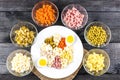 Ingredients shredded for salad in transparent plates on a black wooden background. Olives, pickled cuc Royalty Free Stock Photo