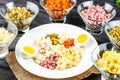 This photo depicts image of Ingredients shredded for salad in transparent plates on a black wooden background. Olives, pickled cuc Royalty Free Stock Photo