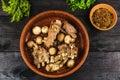 Stewed champignons and beef ribs with onions in a glossy plate, spices, parsley, dill. on a black wooden background. Fried mushroo Royalty Free Stock Photo