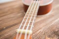 Photo depicts musical instrument ukulele guitar on a wooden table Royalty Free Stock Photo