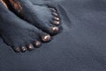 Photo of dirty woman bare feet in black sand Royalty Free Stock Photo