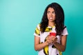 Photo of disgusted displeased girl hold phone look empty space wear banana print t-shirt isolated turquoise color