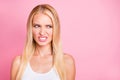 Photo of disgusted lady expressing negative mood after smelling spoiled food wear white tank-top isolated on pink color