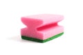 Photo of a dish sponge that consists of pink foam and green abrasive on a white background