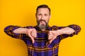 Photo of displease unhappy mature man make thumbs down dislike bad mood isolated on yellow color background Royalty Free Stock Photo