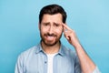 Photo of displeased guy pointing finger forehead dislike friends suggestion isolated blue color background