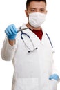 Photo of doctor in mask and white coat in rubber gloves holding tweezers. Royalty Free Stock Photo