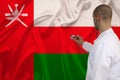 Photo of a doctor with a stethoscope on the background of the Oman national flag on a beautiful silk fabric, the concept of